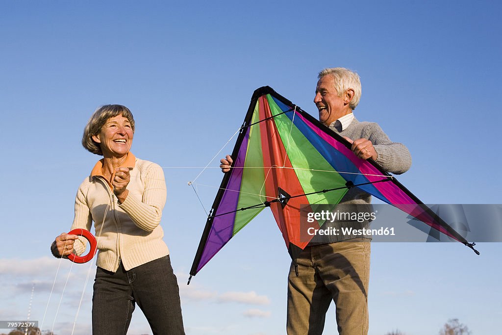 Senior couple, man holding kite