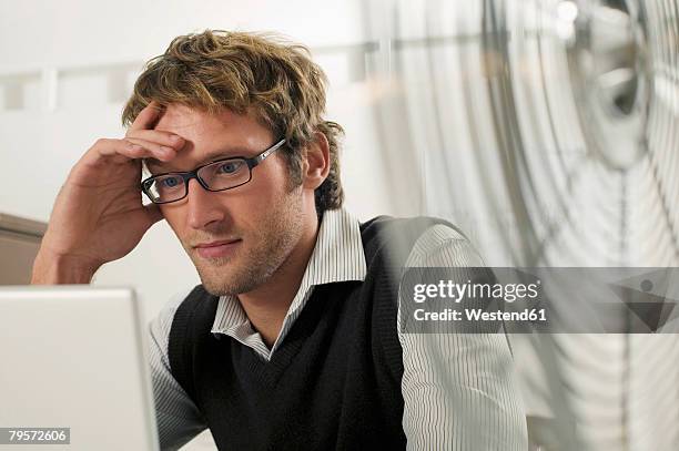 young man working on laptop - portrait of pensive young businessman wearing glasses stock pictures, royalty-free photos & images