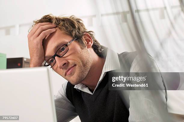 young man working on laptop - portrait of pensive young businessman wearing glasses stock pictures, royalty-free photos & images