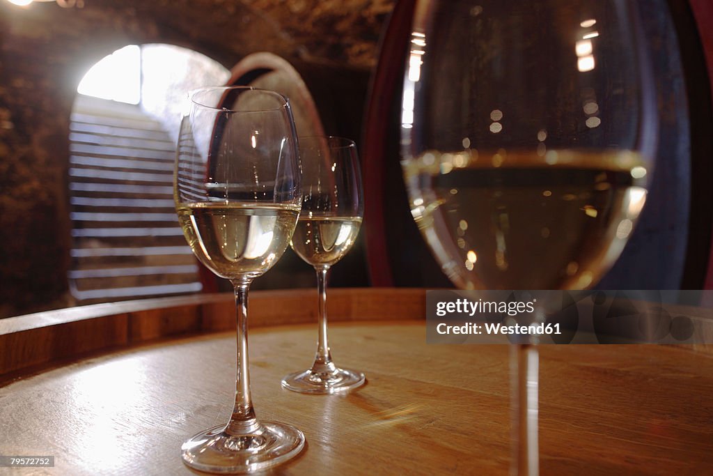 Wite wine in glasses on wine cask