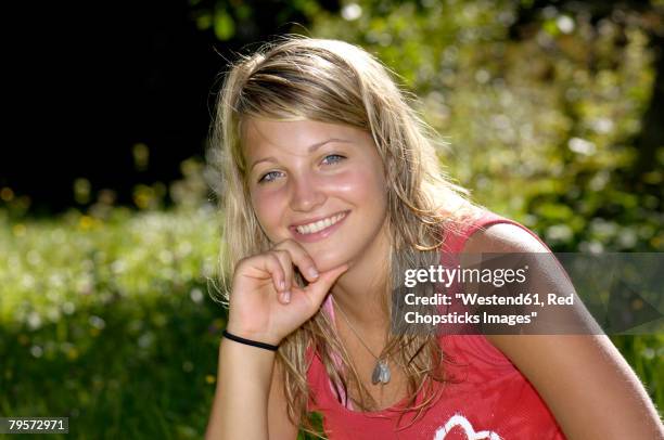 young girl sitting in meadow, portrait - pleading stock pictures, royalty-free photos & images