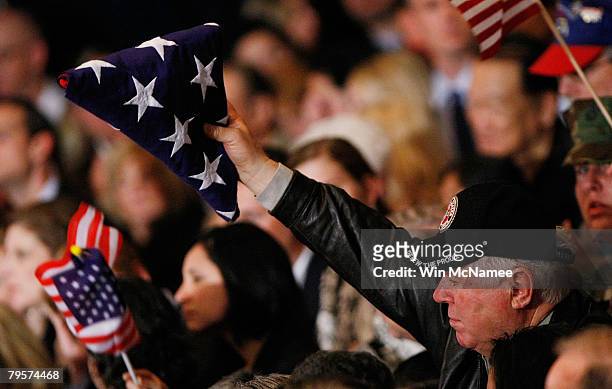 Supporter of Republican presidential candidate Sen. John McCain holds up an American flag as the candidate speaks at a Super Tuesday election party...