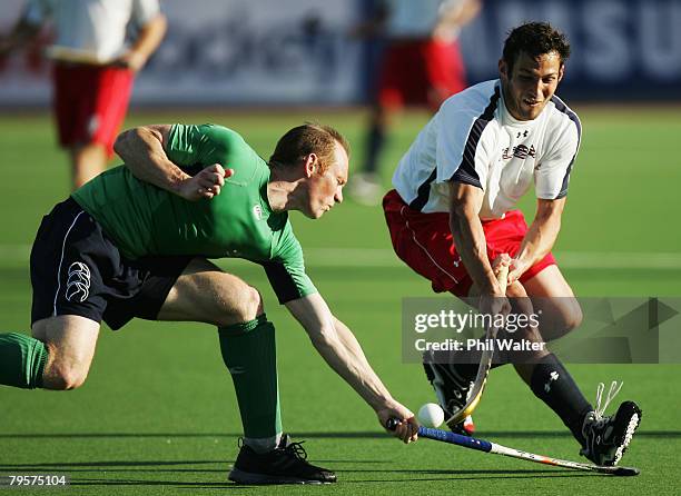 Nate Coolidge of the USA is tackled by Mark Black of Ireland during the Olympic Qualifying Hockey match between Ireland and the United States of...