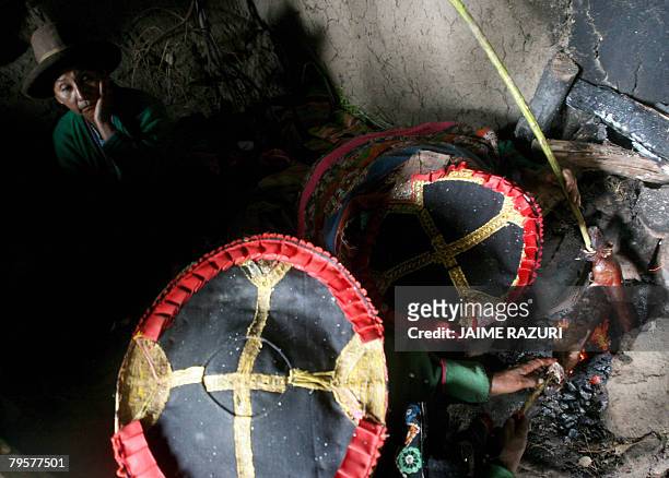 Andean women weavers from Cha'ri, about 150 kms south of Cusco, Peru, cook guinea pigs for lunch during a break from work, 28 January 2008.Cha'ris...