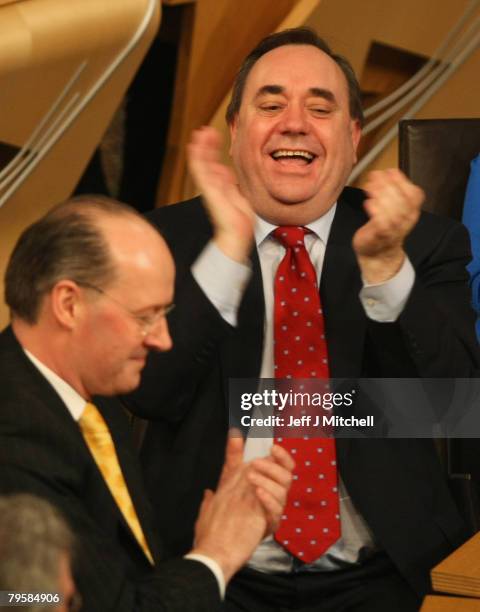 First Minister of Scotland Alex Salmond and Finance Minister John Swinney react after the budget debate at the Scottish Parliament on February 6,...
