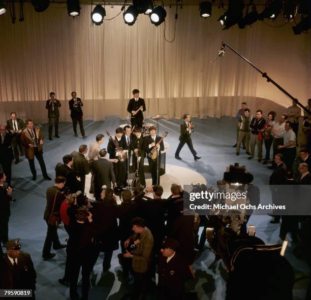 Elevated view of American television personality Ed Sullivan , with the members of British Rock group the Beatles, during a rehearsal for 'The Ed...