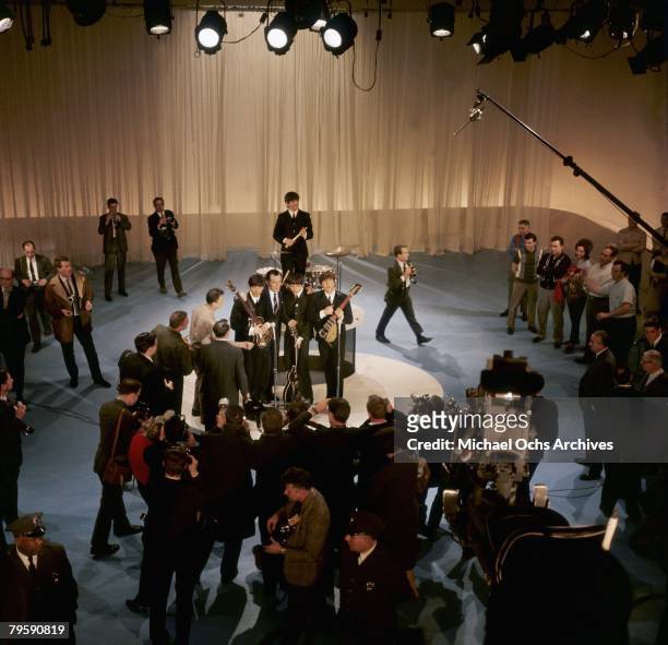 Elevated view of American television personality Ed Sullivan , with the members of British Rock group the Beatles, during a rehearsal for 'The Ed...