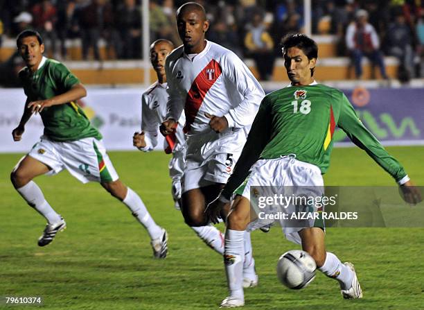 Ricardo Pedriel of Bolivia tries to keep control over the ball under the mark of Miguel Villalta of Peru as his teammate Rolando Rivera looks on...