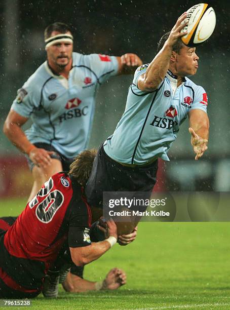 Timana Tahu of the Waratahs gets a pass away as he is tackled during the Rotomahana Challenge match between the New South Wales Waratahs and the...