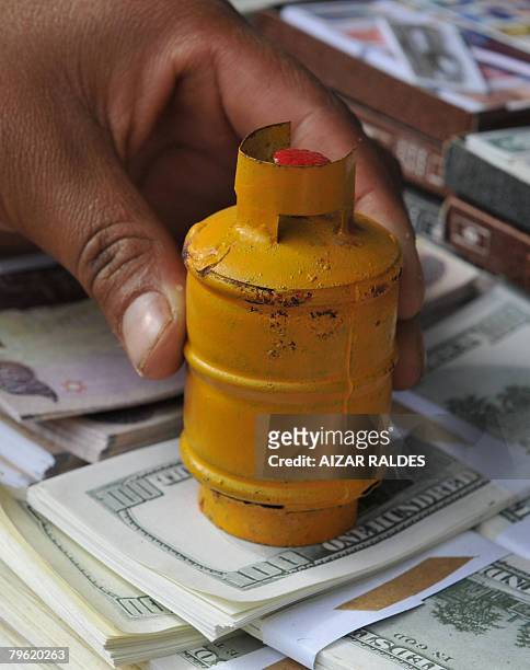 An aymara native sells tiny gas bottles during the traditional Alasitas fair in La Paz on February 1, 2008. According to the Aymara tradition, in...