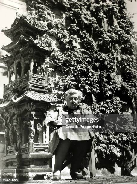 English writer and novelist Agatha Christie seated in a chair in the grounds of her home, Winterbrook House near Wallingford, Oxfordshire in 1950....