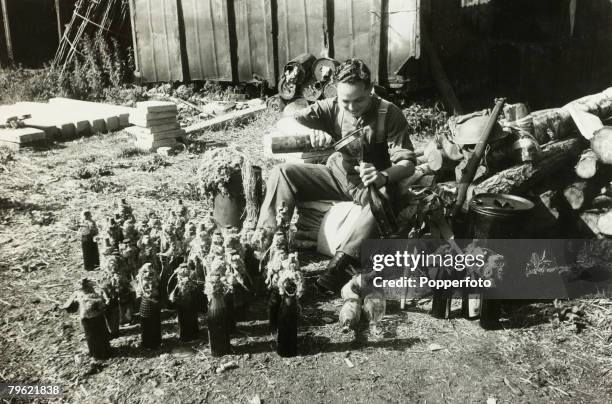 War and Conflict, World War Two, pic: July 1940, Britain, A guard making a "Molotov Cocktail" with an explosive mixture put into a bottle, in the...