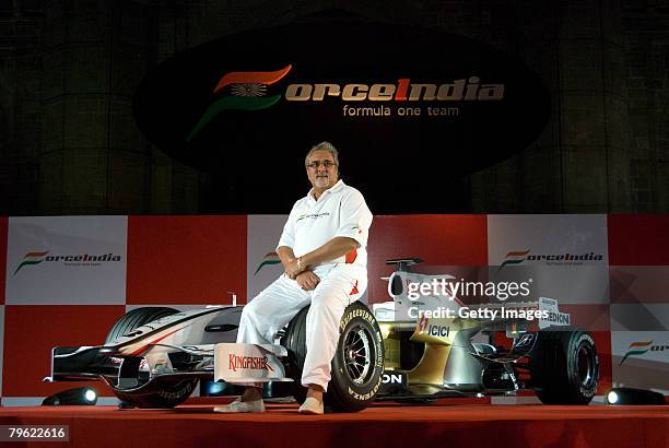 Chairman of Force India F1 team, Vijay Mallya, poses with the new Force India Formula One Team car on display at the launch held infront of the...