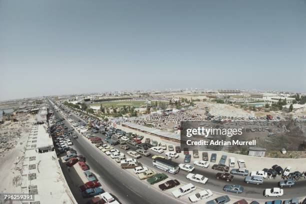 Motor cars are parked outside the ground as spectators gather for the Rothmans Asia Cup cricket match between Pakistan and Sri Lanka on 6 April 1984...