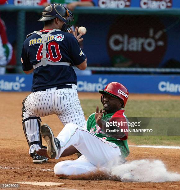 Riggie Taylor of Mexican Yaquis slides into home plate past Venezuelan Wilson Ramos during a Caribbean Series game at Cibao stadium in Santiago de...