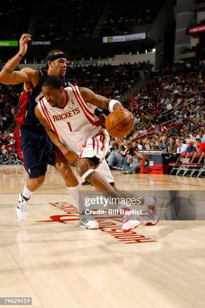 Tracy McGrady of the Houston Rockets dribbles the ball past Larry Hughes of the Cleveland Cavaliers on February 7, 2008 at the Toyota Center in...