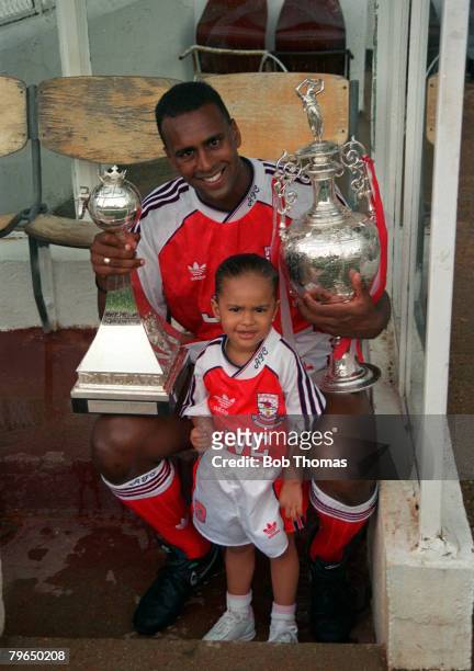 Arsenal's David Rocastle with his child and the First Division Championship trophies won by the club in season 1990-1991