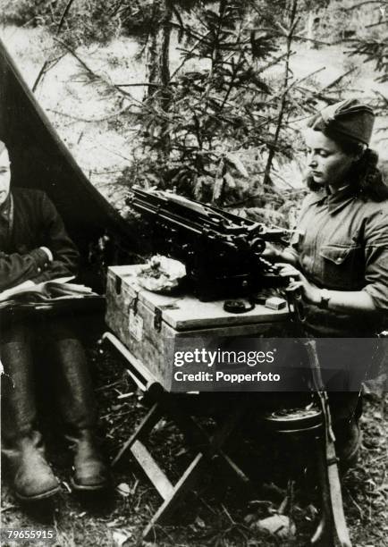 War and Conflict, World War Two, pic: circa 1941, A Russian Army girl typist at work in her makeshift office on the northern front with her tommy gun...