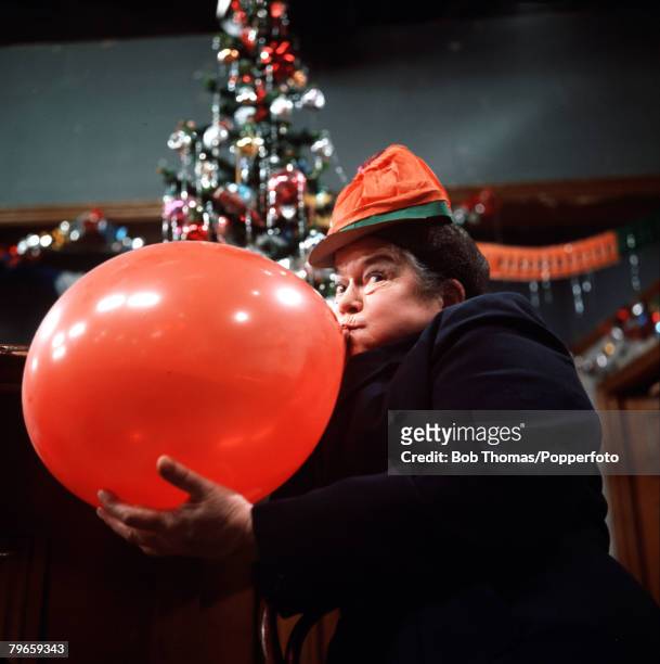 England, Circa 1960's, Actress Violet Carson who plays the role of Ena Sharples in the television series "Coronation Street" is pictured blowing up a...