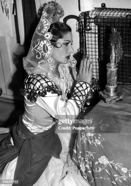 London, England, 15th June 1948, Spanish Gypsy dancer Carmen Amaya prays before each performance at a shrine to the Madonna that she has placed in...