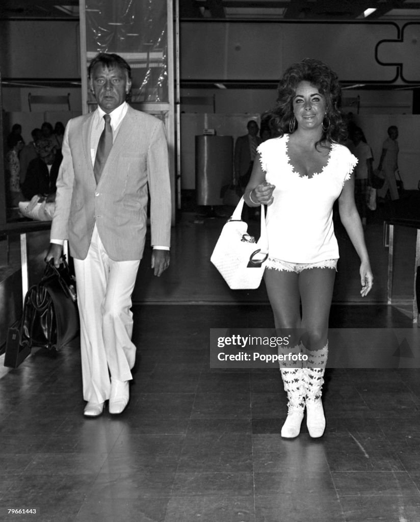 London, England, 29th July 1971, Film actress Elizabeth Taylor is pictured leaving Heathrow for a Mediterranean holiday with husband Richard Burton (left), She is wearing a lace hotpants suit