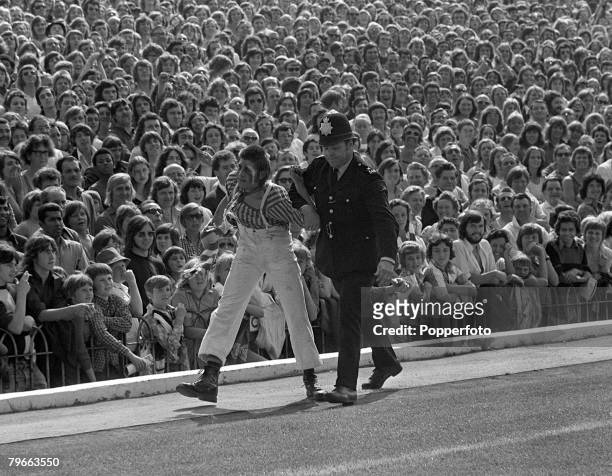 Sport, Football, English League Division One, London, England, 25th August 1973, Arsenal v Manchester United, A policemen ejects a "fan" watched by a...