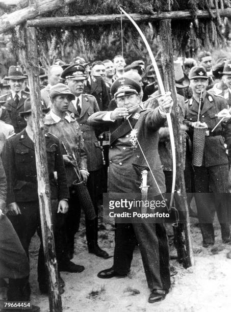 Pre-World War II, 30th June 1939, Field Marshal Goering displays his skill with a bow during a meeting of the German forest society in the...