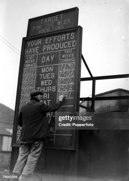 15th February 1947, Kent, England, A picture of a miner writing the weekly production totals on a blackboard, as they are working hard to exceed...