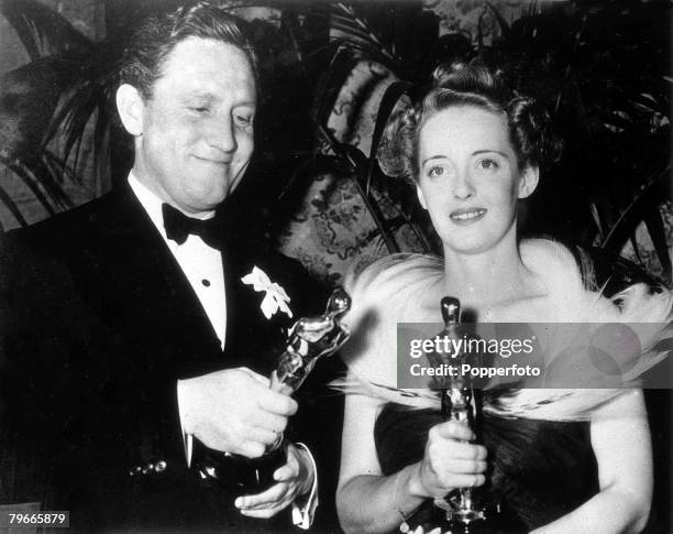 Hollwood, California, US Film stars Bette Davis with her academy award for Jezebel with Spencer Tracy with his award for the film Boys Town at the...