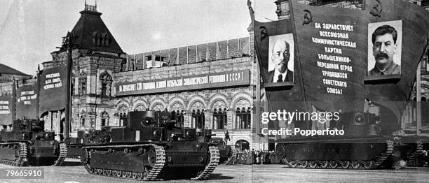 World War II, 27th December 1940, Tanks roll past huge portraits of Lenin and Stalin in Moscow's Red Square in celebration of the 23rd Anniversary of...