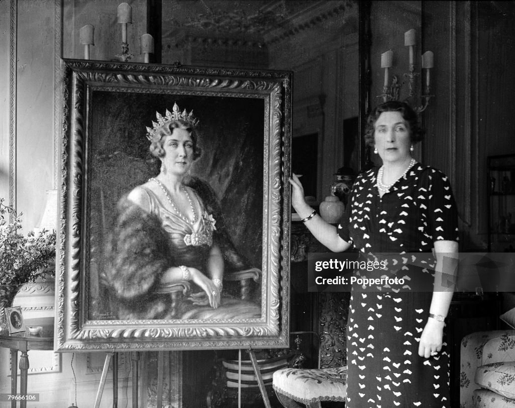 31st July 1938, Queen Ena of Spain poses with a portrait painted of her by artist Tosti Russell