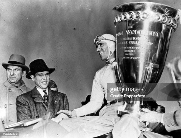 Motor Racing, 19th October 1936, Italian racing driver Tazio Nuvolari holds the huge Vanderbilt trophy after winning the Vanderbilt cup race at long...