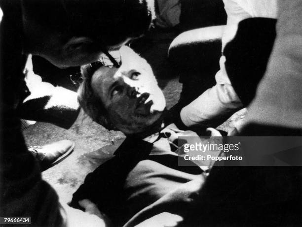 5th June 1968, Senator Robert F, Kennedy lies on the floor of the Ambassador hotel, his shirt is opened and he looks up at people assisting him, just...