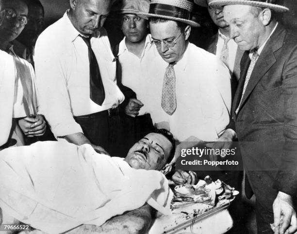 The body of John Dillinger, America's "Public Enemy No. 1," lies on a slab in a morgue room, surrounded by policemen, after he was shot dead by...