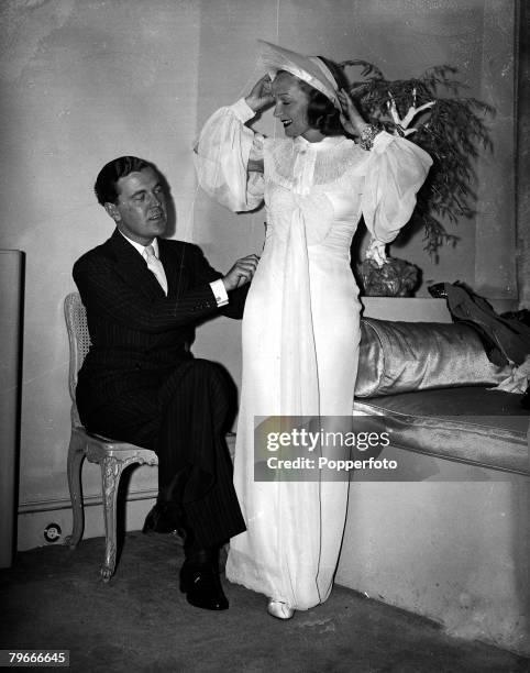 16th September 1936, Dress designer Norman Hartnell fits actress Florence Desmond for a wedding gown at his Mayfair, London salon, Miss Desmond is to...