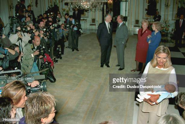 In foreground, Infanta Christina with baby Pablo Nicolas, in background: Juan Maria Urdangarin talking to King Juan Carlos, Claire Urdangarin and...