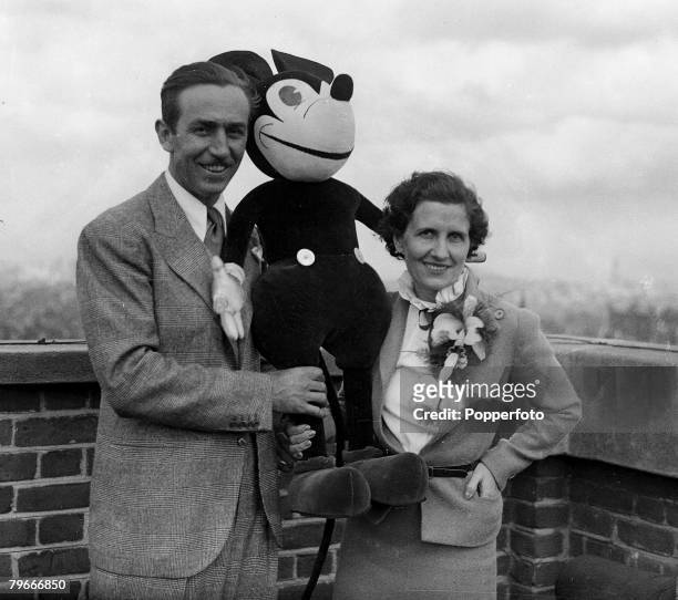 Cartoons and Animation, 12th June 1935, Famous American animator Walt Disney and his wife, Lillian with cartoon character Mickey Mouse on the roof of...