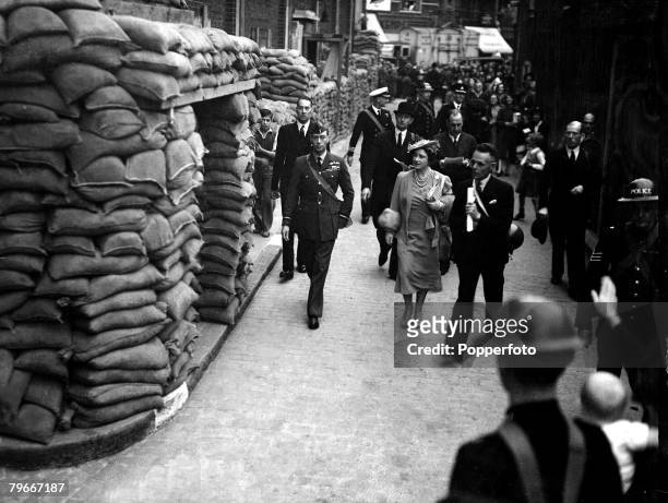 World War II, 11th September 1939, King George VI and Queen Elizabeth, later the Queen Mother, carrying gas-masks, inspecting sand-bags during a tour...
