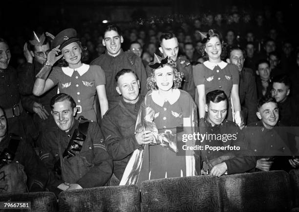 10th October 1939, Show girls join the fifteen hundred army soldiers in the London auditorium to watch the first big show of the year in response to...