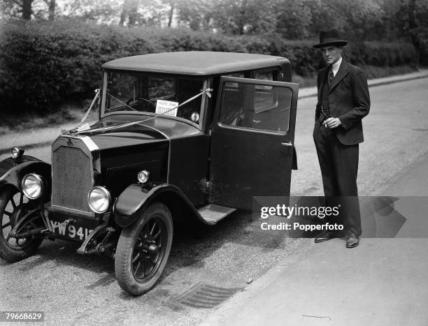 London, England, Randolph Churchill, son of politician Winston Churchill, standing next to his motorcar before setting out to campaign for his father...