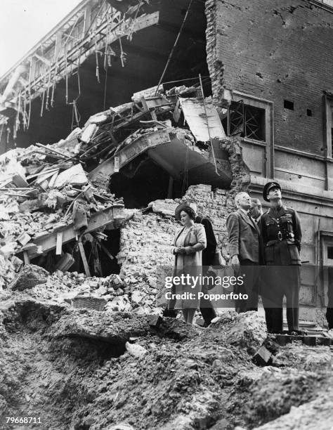 King George VI and Queen Elizabeth inspect the damage to a cinema building in Baker Street after it was destroyed by Nazi bombing in an air raid over...