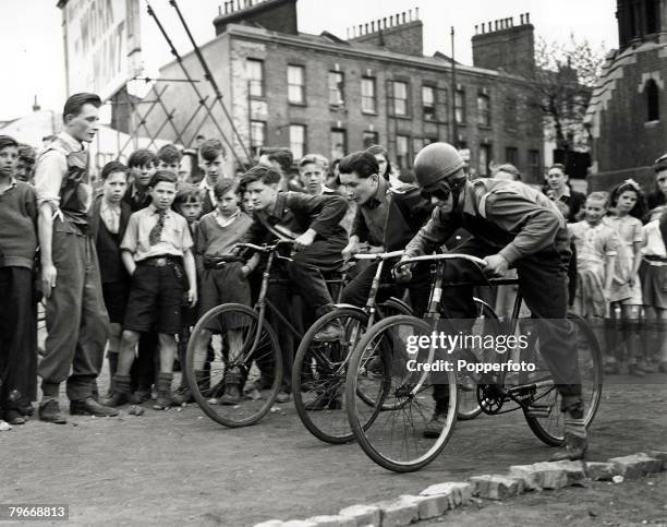 Classic Collection, Page 71 10th May 1947, Three young boys on bicycles, with crowd watching, about to start a ,speedway race at a track they built...