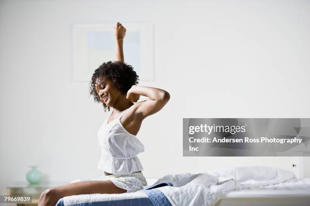 african american woman stretching - levantarse fotografías e imágenes de stock