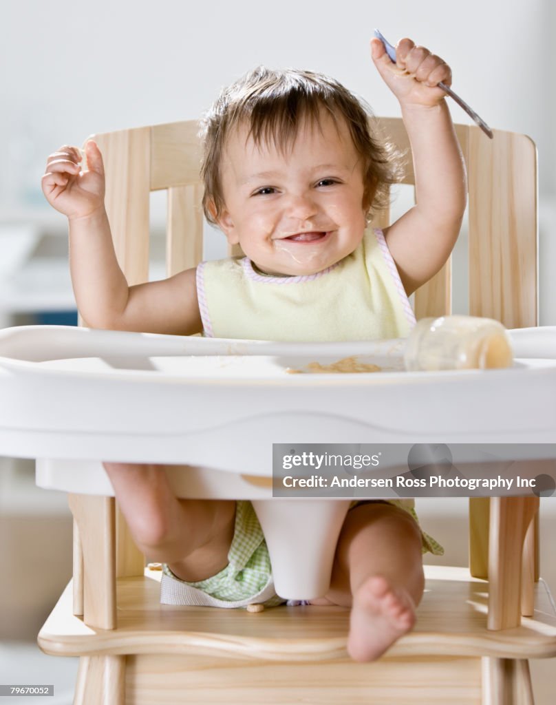 Hispanic baby sitting in highchair