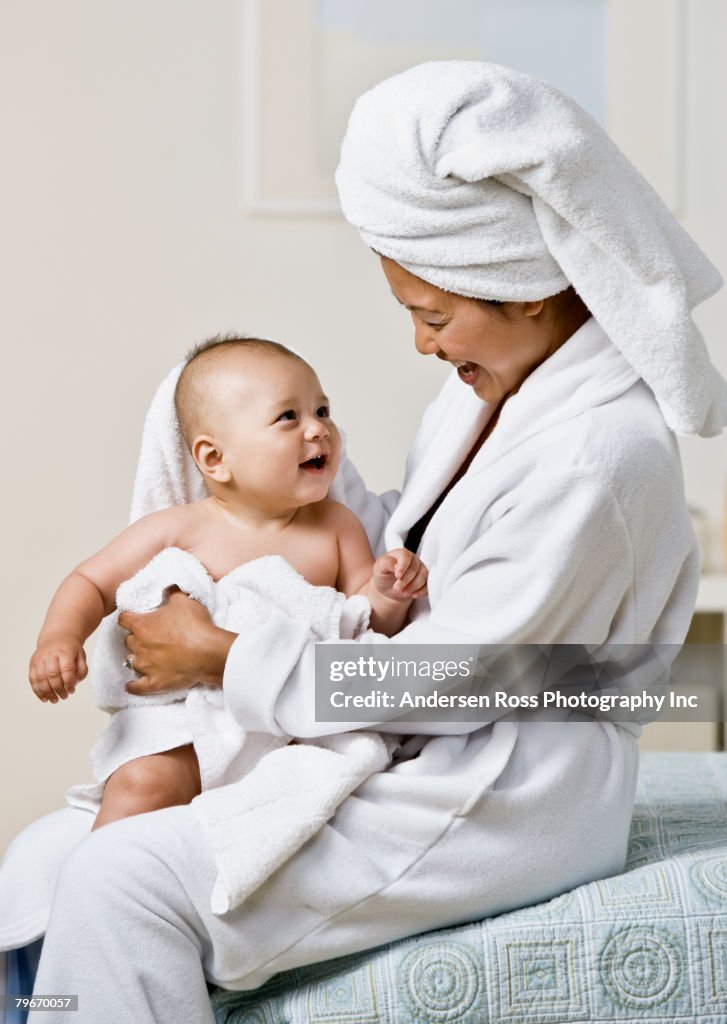 Asian mother drying off baby