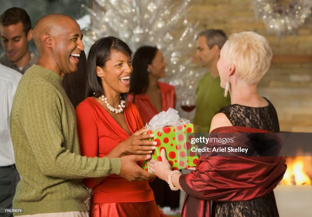 African American couple giving gift at party