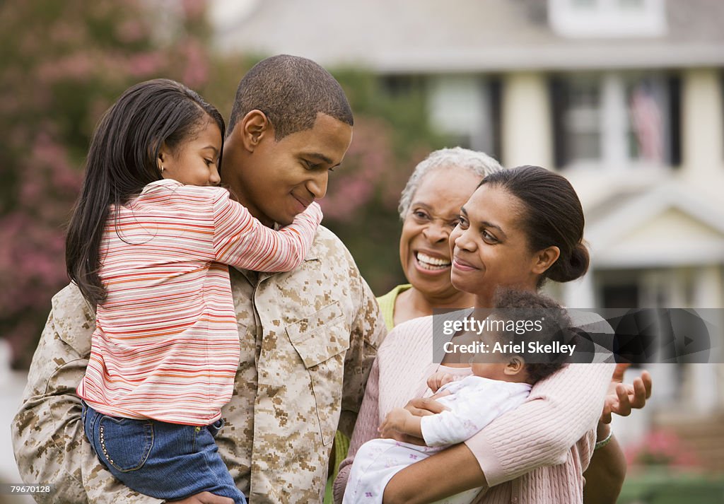 African American military father hugging family