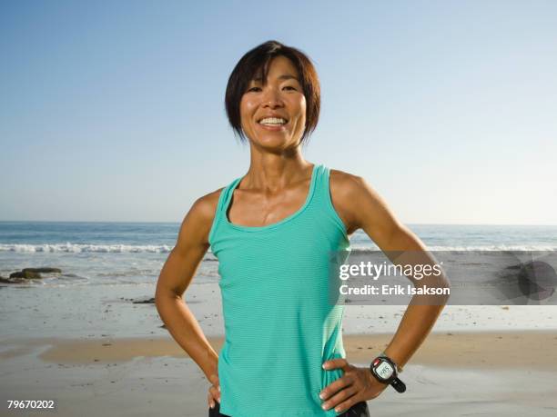 asian woman with hands on hips - female 40 year old beach stock pictures, royalty-free photos & images