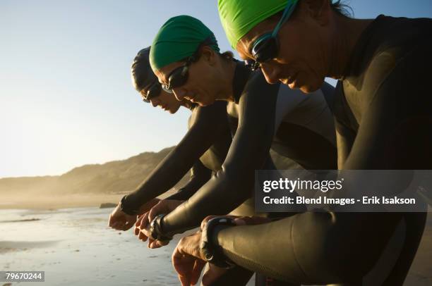 multi-ethnic swimmers checking watches - 48 hours stock-fotos und bilder