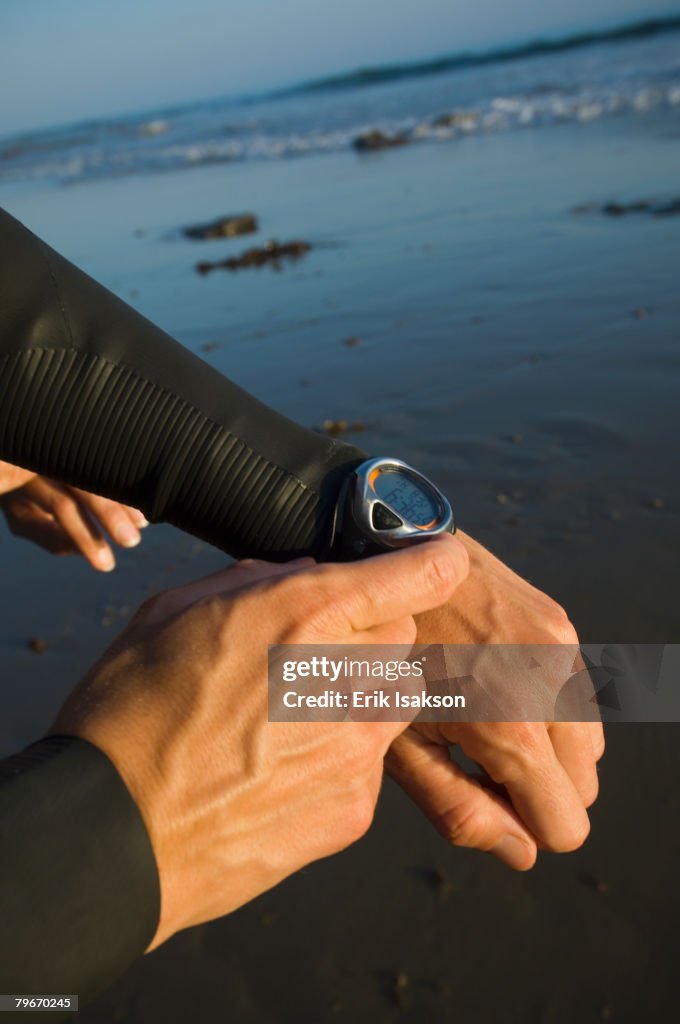 Hispanic male swimmer checking watch